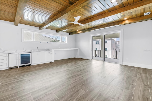 646 Calle Del Otono, Sarasota, FL 34242 - unfurnished living room featuring beverage cooler, a wood ceiling with exposed beams, light wood-type flooring, ceiling fan, and wet bar