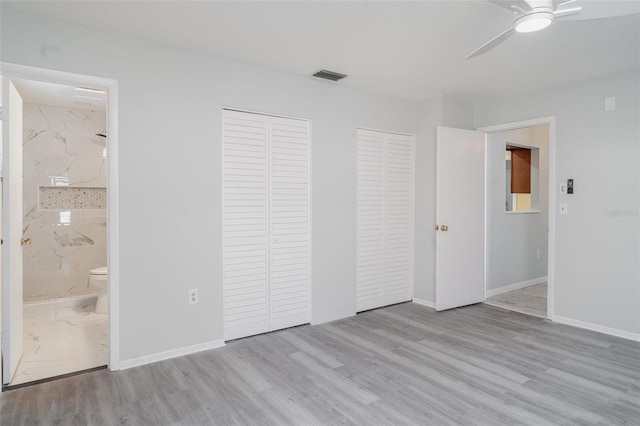 3805 Sandpointe Dr, Bradenton, FL 34205 - unfurnished bedroom featuring multiple closets, wood finished floors, a ceiling fan, and ensuite bathroom