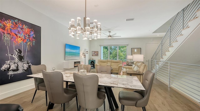 626 Rawls Ave Unit 626, Sarasota, FL 34236 - dining space with a chandelier, light wood-style floors, ceiling fan, and stairway