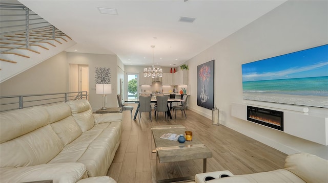 626 Rawls Ave Unit 626, Sarasota, FL 34236 - living room featuring a chandelier, a glass covered fireplace, recessed lighting, and light wood-style floors