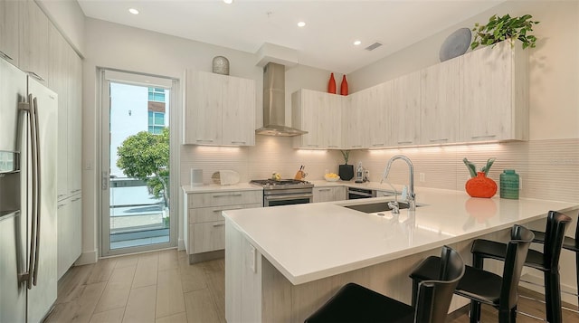 626 Rawls Ave Unit 626, Sarasota, FL 34236 - kitchen featuring wall chimney exhaust hood, stainless steel appliances, modern cabinets, a peninsula, and a kitchen breakfast bar