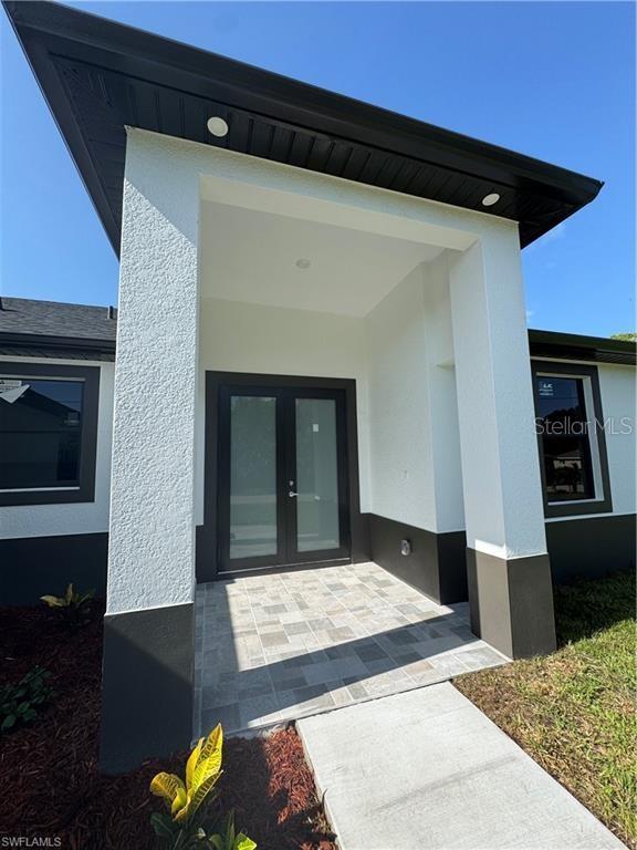 3003 18th St W, Lehigh Acres, FL 33971 - entrance to property featuring stucco siding and french doors