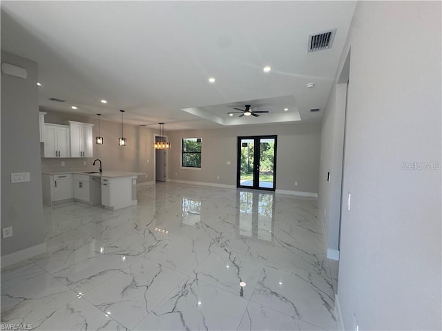 3003 18th St W, Lehigh Acres, FL 33971 - unfurnished living room with a tray ceiling, recessed lighting, a ceiling fan, french doors, and a chandelier