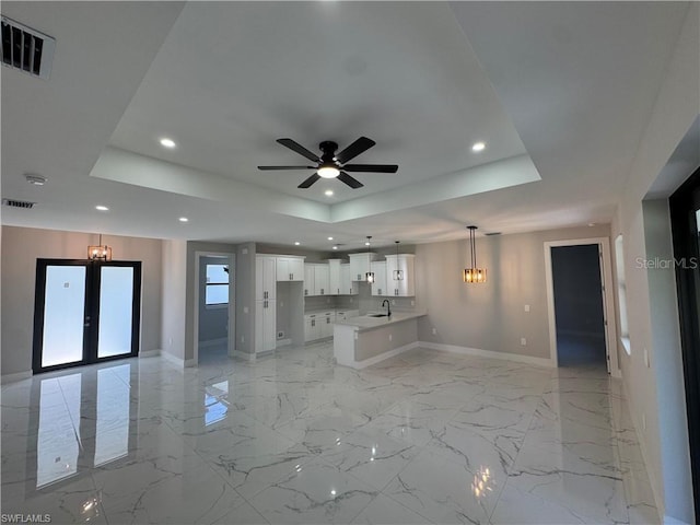 3003 18th St W, Lehigh Acres, FL 33971 - unfurnished living room with a tray ceiling, a chandelier, a ceiling fan, recessed lighting, and light marble finish floors