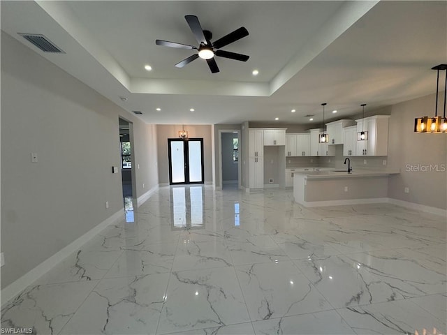 3003 18th St W, Lehigh Acres, FL 33971 - unfurnished living room featuring recessed lighting, ceiling fan, a raised ceiling, a chandelier, and light marble finish flooring