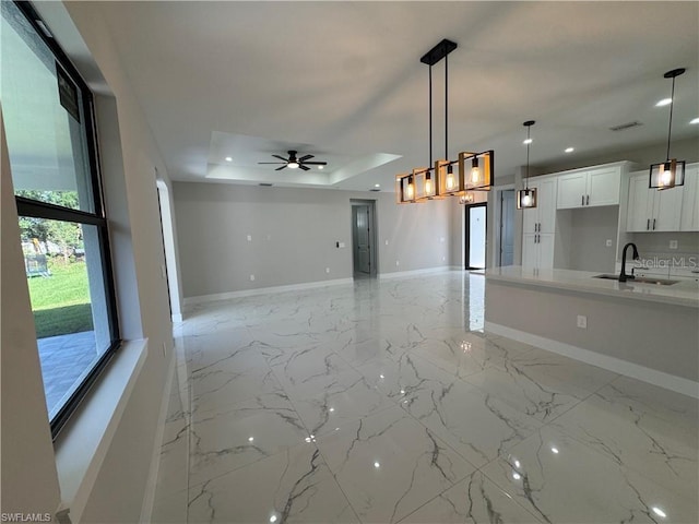 3003 18th St W, Lehigh Acres, FL 33971 - unfurnished living room featuring a raised ceiling, a ceiling fan, light marble finish floors, and recessed lighting