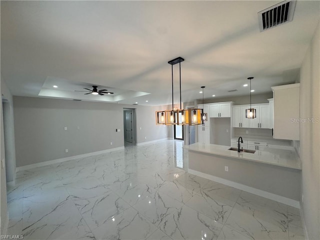3003 18th St W, Lehigh Acres, FL 33971 - kitchen featuring recessed lighting, white cabinetry, a ceiling fan, light countertops, and a raised ceiling