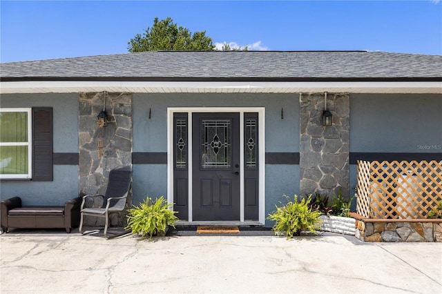 17211 Drayton Ln, Port Charlotte, FL 33948 - doorway to property with a shingled roof, stone siding, stucco siding, and a porch