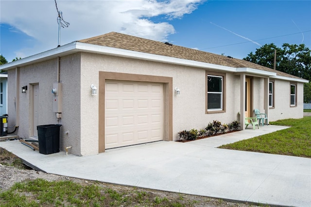 1515 2nd Ave W, Palmetto, FL 34221 - view of side of home featuring stucco siding, a garage, driveway, and roof with shingles