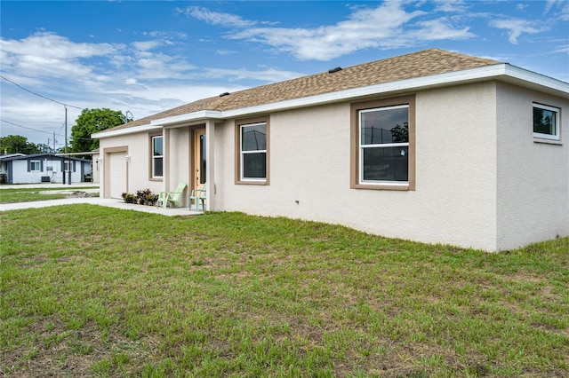 1515 2nd Ave W, Palmetto, FL 34221 - view of front facade with stucco siding, a garage, a front lawn, and a shingled roof