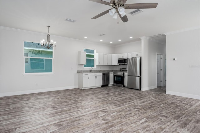 1515 2nd Ave W, Palmetto, FL 34221 - kitchen with appliances with stainless steel finishes, wood finished floors, open floor plan, ornamental molding, and recessed lighting