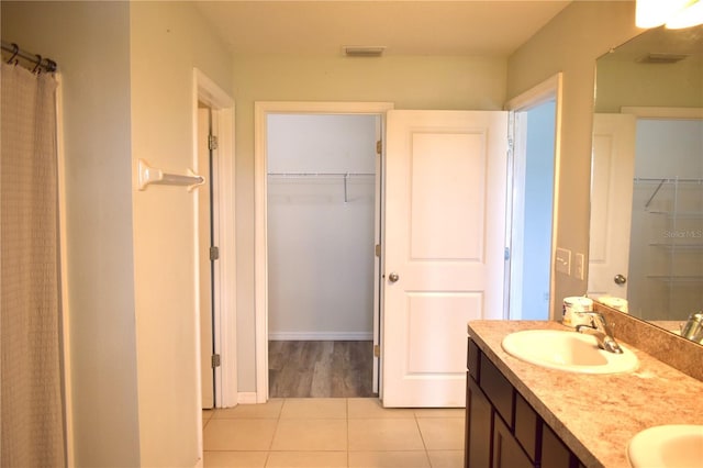 10019 Geese Trail Cir, Sun City Center, FL 33573 - full bathroom with tile patterned floors, double vanity, and a walk in closet