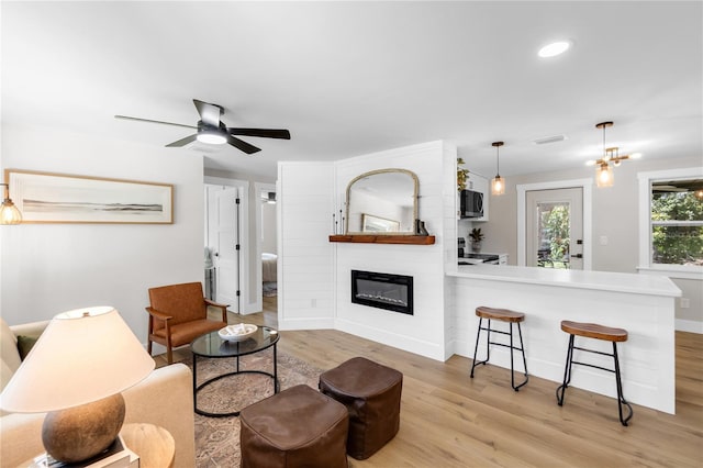 4041 Linwood St, Sarasota, FL 34232 - living room with light wood-style flooring, a fireplace, a ceiling fan, and recessed lighting