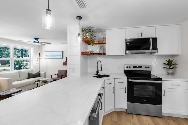 4041 Linwood St, Sarasota, FL 34232 - kitchen with stainless steel appliances, open shelves, tasteful backsplash, a ceiling fan, and white cabinetry