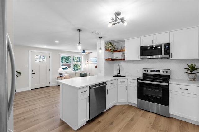 4041 Linwood St, Sarasota, FL 34232 - kitchen featuring appliances with stainless steel finishes, a peninsula, decorative backsplash, white cabinets, and recessed lighting