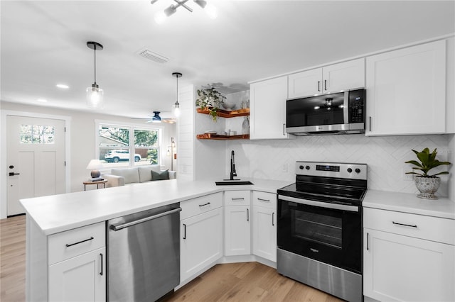 4041 Linwood St, Sarasota, FL 34232 - kitchen featuring stainless steel appliances, a peninsula, open shelves, light countertops, and recessed lighting
