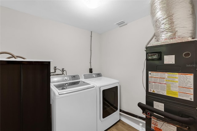 4041 Linwood St, Sarasota, FL 34232 - washroom featuring washing machine and clothes dryer, light wood finished floors, and heating unit