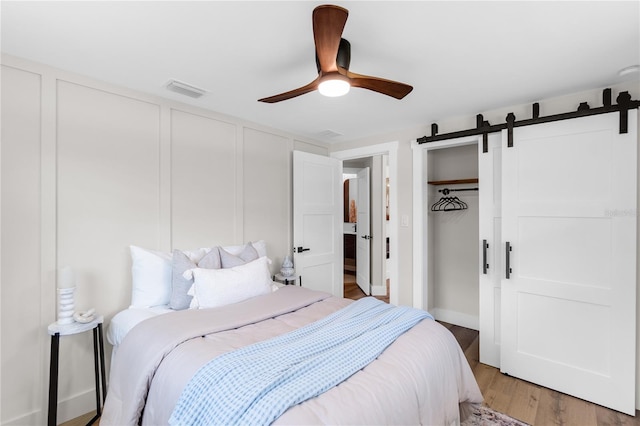 4041 Linwood St, Sarasota, FL 34232 - bedroom with light wood finished floors, ceiling fan, and a barn door