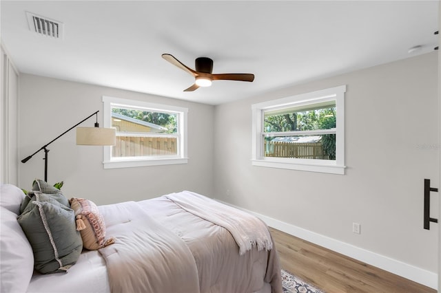 4041 Linwood St, Sarasota, FL 34232 - bedroom with multiple windows, wood finished floors, and a ceiling fan