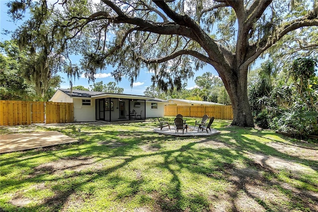 4041 Linwood St, Sarasota, FL 34232 - fenced backyard with an outdoor fire pit and a patio