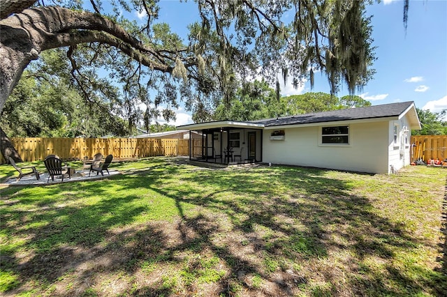 4041 Linwood St, Sarasota, FL 34232 - rear view of house with a sunroom, a fenced backyard, a fire pit, and a patio