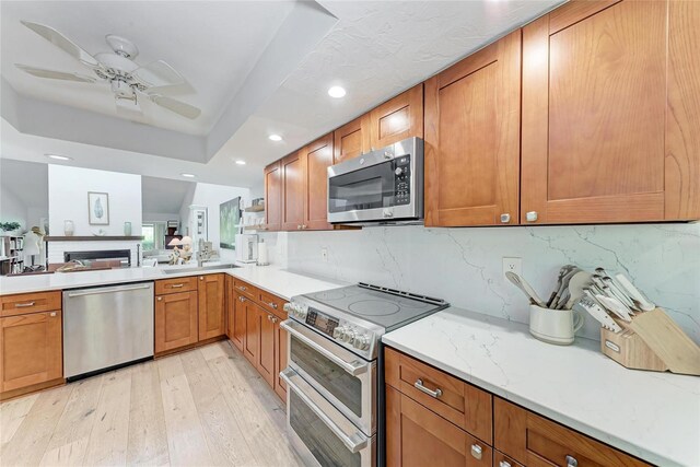 6111 Courtside Dr Unit 61, Bradenton, FL 34210 - kitchen featuring appliances with stainless steel finishes, light wood-style flooring, ceiling fan, recessed lighting, and decorative backsplash