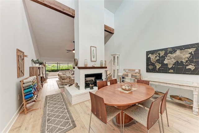 6111 Courtside Dr Unit 61, Bradenton, FL 34210 - dining area with high vaulted ceiling, a fireplace, light wood-type flooring, and a ceiling fan