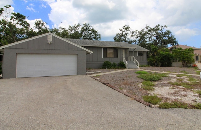 753 Tropical Cir, Sarasota, FL 34242 - ranch-style house with driveway, board and batten siding, an outdoor structure, and a garage