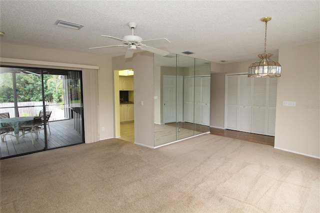 753 Tropical Cir, Sarasota, FL 34242 - carpeted empty room with ceiling fan, a textured ceiling, and a chandelier