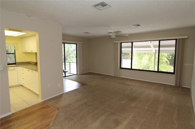 753 Tropical Cir, Sarasota, FL 34242 - unfurnished living room with a textured ceiling, a ceiling fan, and light carpet