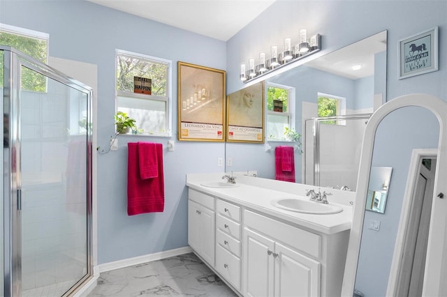 7747 33rd St E, Sarasota, FL 34243 - bathroom featuring double vanity, marble finish floors, healthy amount of natural light, and a shower stall
