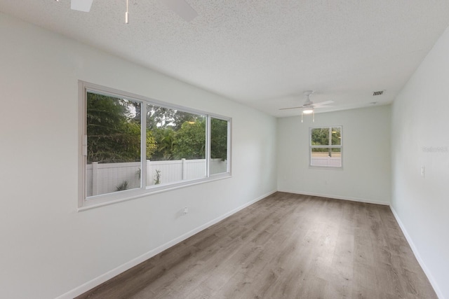 8985 Pohoy Ave, Sarasota, FL 34231 - empty room with a ceiling fan, wood finished floors, and a textured ceiling