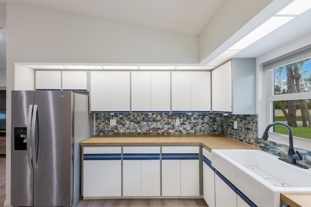8985 Pohoy Ave, Sarasota, FL 34231 - kitchen with stainless steel refrigerator with ice dispenser, tasteful backsplash, white cabinets, and butcher block countertops