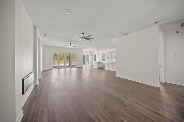 8146 Tropicaire Blvd, North Port, FL 34291 - unfurnished living room featuring ceiling fan, dark wood-type flooring, and a fireplace