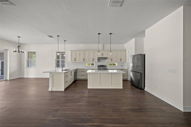 8146 Tropicaire Blvd, North Port, FL 34291 - kitchen with appliances with stainless steel finishes, dark wood-style floors, a textured ceiling, a peninsula, and light countertops