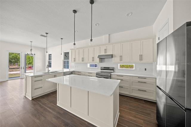 8146 Tropicaire Blvd, North Port, FL 34291 - kitchen with stainless steel appliances, a peninsula, under cabinet range hood, dark wood finished floors, and recessed lighting