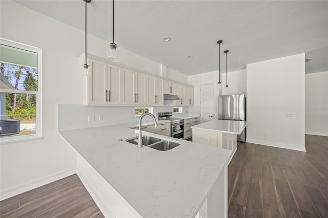 8146 Tropicaire Blvd, North Port, FL 34291 - kitchen featuring stainless steel appliances, under cabinet range hood, a center island, dark wood-style flooring, and white cabinets