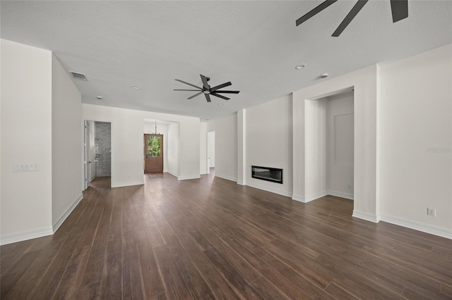 8146 Tropicaire Blvd, North Port, FL 34291 - unfurnished living room with a ceiling fan, dark wood-style floors, and a glass covered fireplace