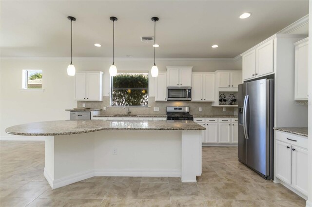 11221 Sandhill Preserve Dr, Sarasota, FL 34238 - kitchen with stainless steel appliances, a kitchen island, healthy amount of natural light, white cabinets, and crown molding