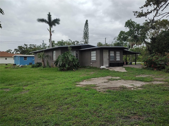 1423 17th Ave E, Bradenton, FL 34208 - back of house featuring a lawn and an attached carport