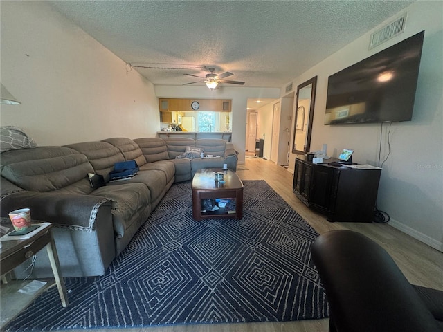 1999 Kings Hwy Unit 26A, Punta Gorda, FL 33980 - living area with a textured ceiling, a ceiling fan, and light wood finished floors