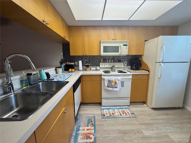 1999 Kings Hwy Unit 26A, Punta Gorda, FL 33980 - kitchen featuring white appliances, backsplash, light countertops, light wood-style flooring, and brown cabinetry