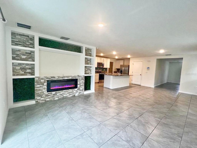 2824 Rock Sound St, Bradenton, FL 34208 - unfurnished living room with recessed lighting, a glass covered fireplace, built in features, and light tile patterned floors