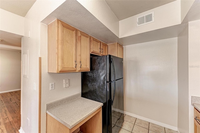 1030 Villagio Cir Unit 103, Sarasota, FL 34237 - kitchen with freestanding refrigerator, light countertops, light brown cabinetry, and light tile patterned floors