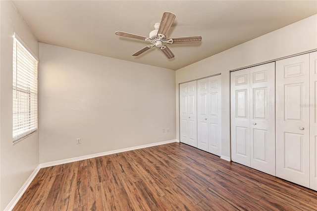 1030 Villagio Cir Unit 103, Sarasota, FL 34237 - unfurnished bedroom featuring wood finished floors, multiple closets, and ceiling fan