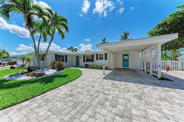 726 Jungle Queen Way, Longboat Key, FL 34228 - view of front of house featuring decorative driveway, stucco siding, and a carport