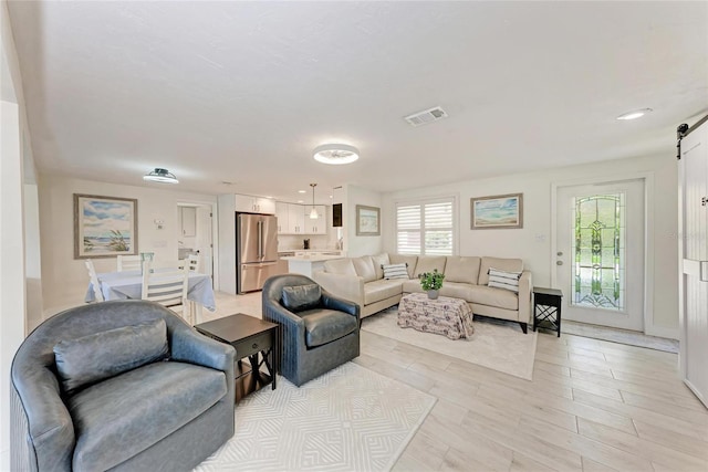 726 Jungle Queen Way, Longboat Key, FL 34228 - living room with a barn door and light wood finished floors