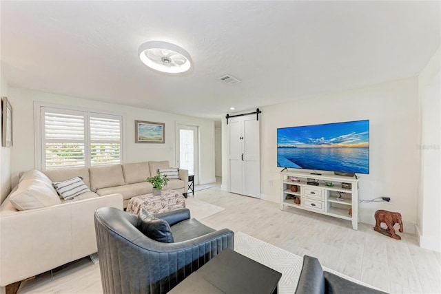 726 Jungle Queen Way, Longboat Key, FL 34228 - living area featuring a barn door and light wood-style floors