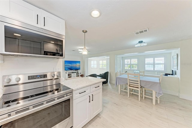 726 Jungle Queen Way, Longboat Key, FL 34228 - kitchen with appliances with stainless steel finishes, white cabinets, light stone countertops, decorative light fixtures, and ceiling fan
