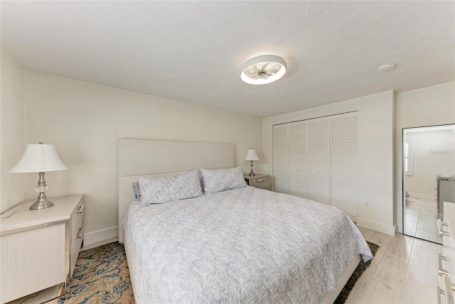 726 Jungle Queen Way, Longboat Key, FL 34228 - bedroom with light wood-type flooring, a closet, and connected bathroom